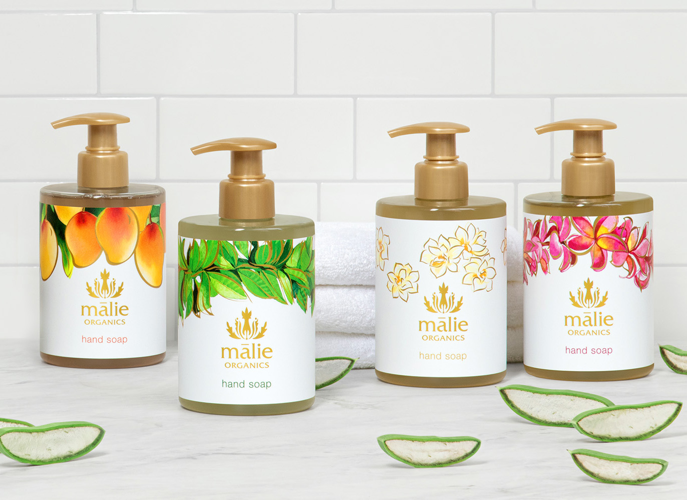 Mālie Organics hand soaps in mango, green botanical, white floral, and pink floral bottles.